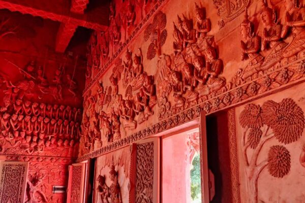 Komplett roter Innenraum des Wat Sila Ngu Tempels - die Lebensgeschichte Buddhas ist an den Wänden zu sehen.