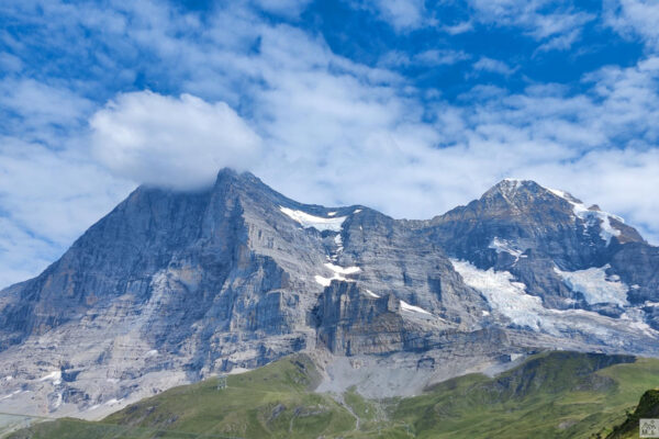 Berge mit blauem Himmel und grünen Alpwiesen.